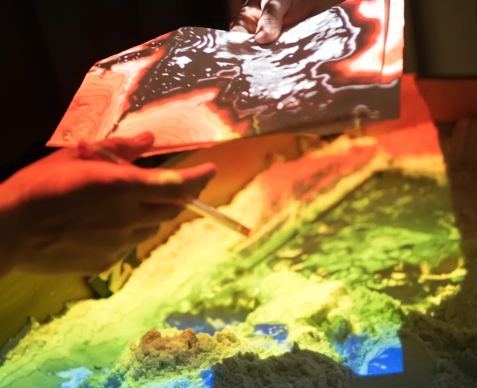 Hands holding a peice of paper under the augmented reality light/box.