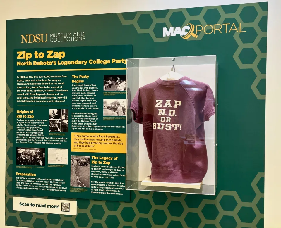 Zip to Zap portal containing text information and a maroon sweatshirt displayed in display case. 