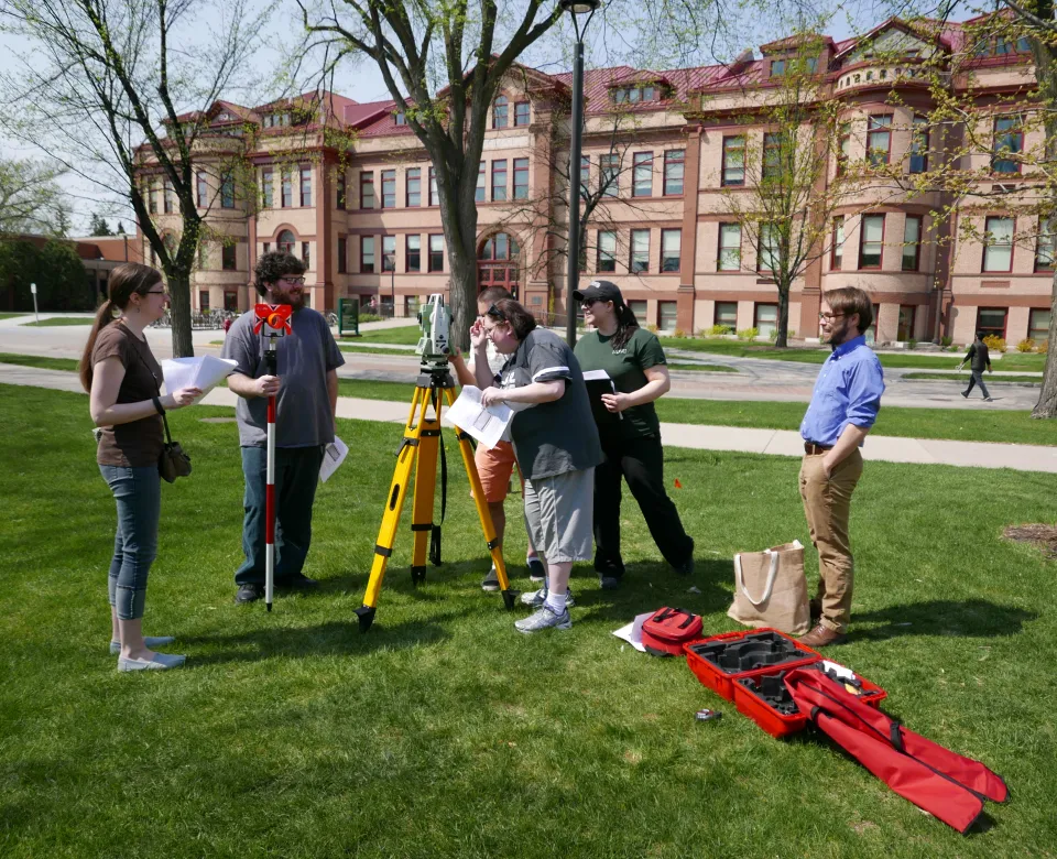 Students conducting research outside on campus under faculty supervision.