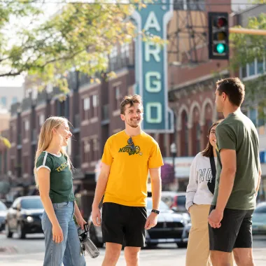 group of students standing downtown in front of Fargo Theatre sign