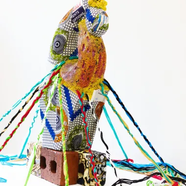 A fabric sculpture sits atop a brick. This image links to the artists website.
