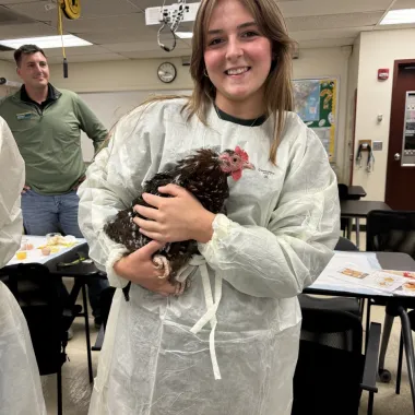 Scholar holding a chicken