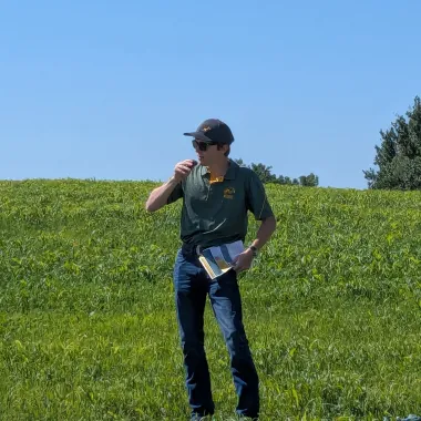 Grad student presenting research standing in field