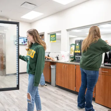 Student grabbing food out of the stand up cold case