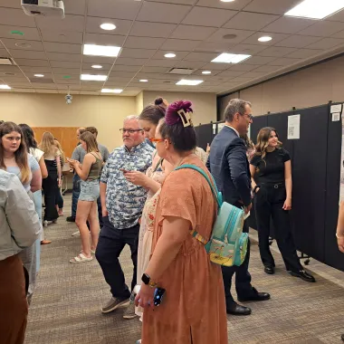Group of people looking at a presentation boards at the CCPAC Open House Spring 2024