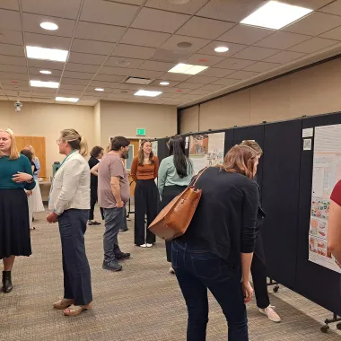 Group of people looking at a presentation boards at the CCPAC Open House Spring 2024
