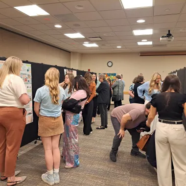 Group of people looking at a presentation boards at the CCPAC Open House Spring 2024