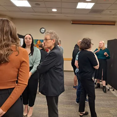 Faculty looking at a presentation board at the CCPAC Open House Spring 2024