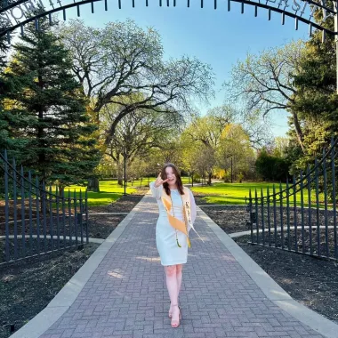 graduate in front of NDSU gates