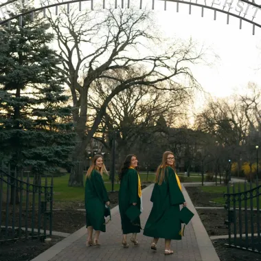 graduates posing in front of the NDSU gate