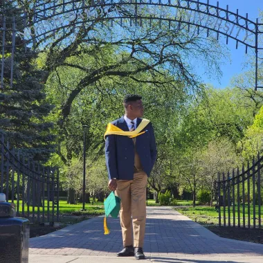 graduate in front of NDSU gates