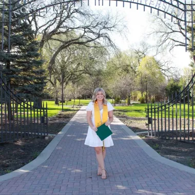 graduate in front of NDSU gates