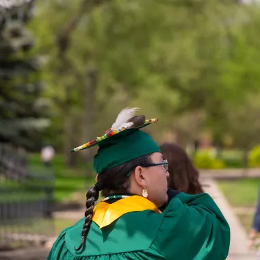 graduate in front of NDSU gates