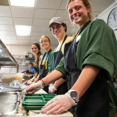 students serve cafeteria food as part of Serve with the Herd