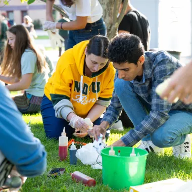 students tie dye shirts on the lawn during Welcome Week