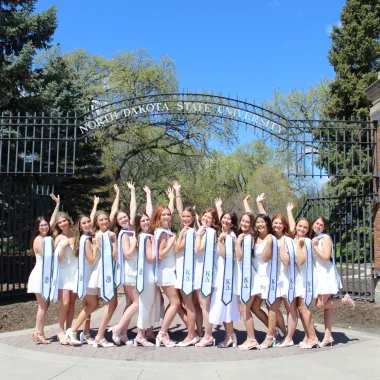 group of students posing for a photo at the main gate