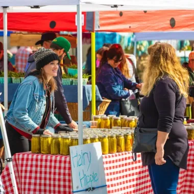a vendor at the Red River Market speaks with a customer
