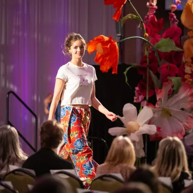 Model wearing white shirt and colorful pants.