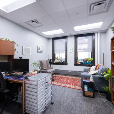 Staff office with comfortable seating, resources, and plants.