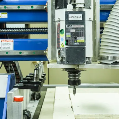 Woodshop machine set to cut a piece of wood.