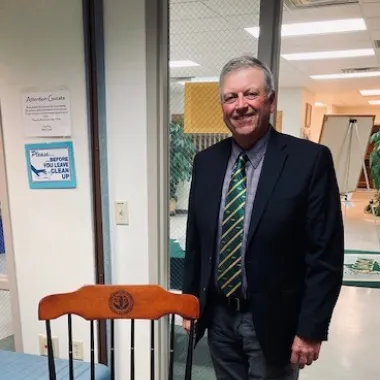 Mark Birdsall standing beside a rocking chair