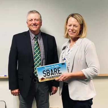 Mark Birdsall and Sarah Lovas with SBARE license plate