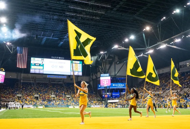 Cheerleaders hoisting flags at 2024 Homecoming NDSU vs. Towson game
