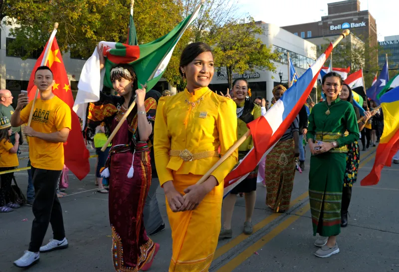 international student holding their countries flags at the Homecoming parade