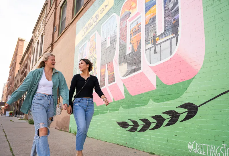students walking past Fargo mural in downtown Fargo