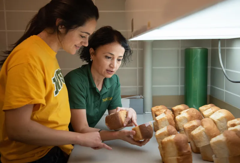 professor showing a student freshly baked bread
