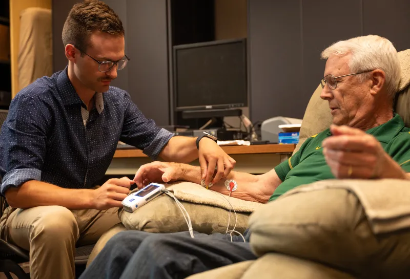 student placing test leads on a patient