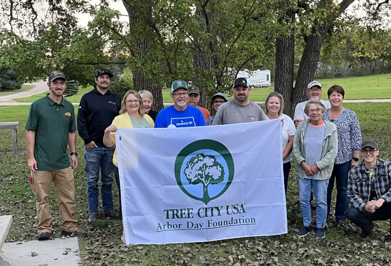 A group of people hold up a flag smiling
