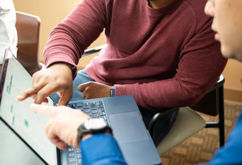 student and professor working together at laptop
