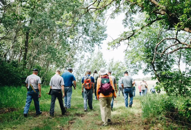 A group of people walk through a forest
