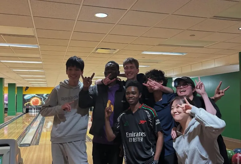 Students with horns up at bowling alley