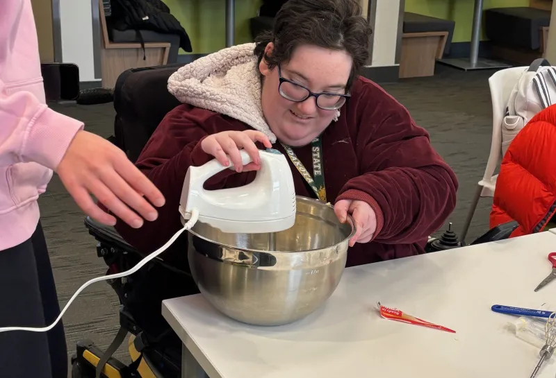 student using a mixer while cooking