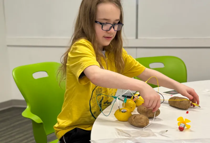 young boy creating electricity with potatoes