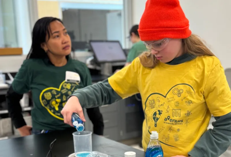 young girl measuring soap into beaker at STEM event