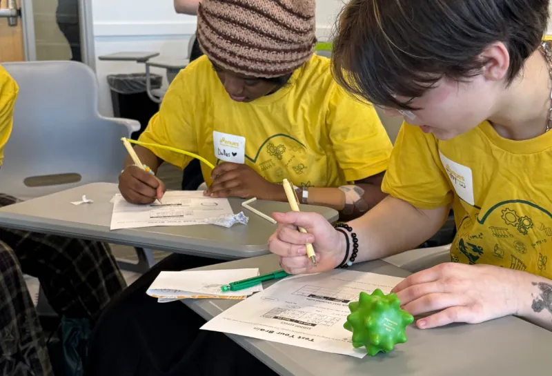 two girls recording observations at STEM event