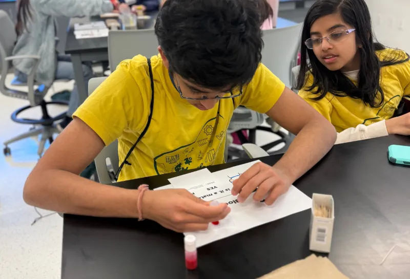boy recording observations at a STEM event