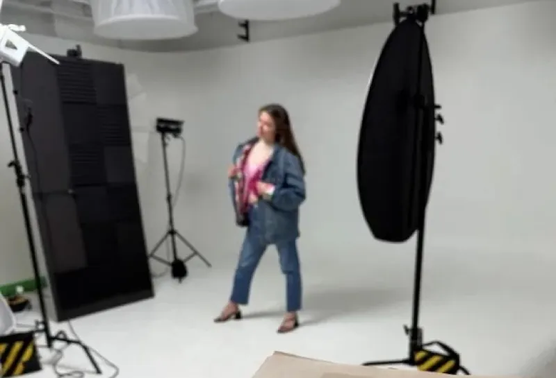 Student posing in front of camera wearing jeans and a jean jacket.