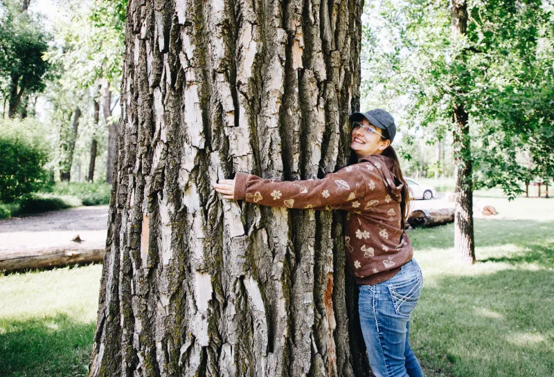A woman hugs a tree