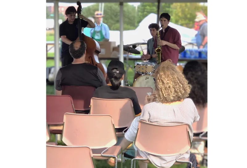 men play instruments under tent