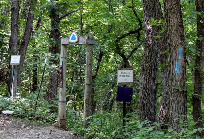 A trailhead for the North Country Trail leading to a waterfall
