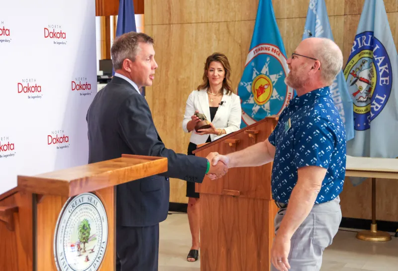 A man shakes another man's hand