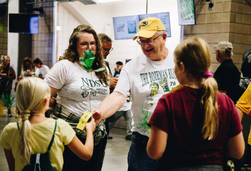 A man with a smile on his face reaches out for a tree 