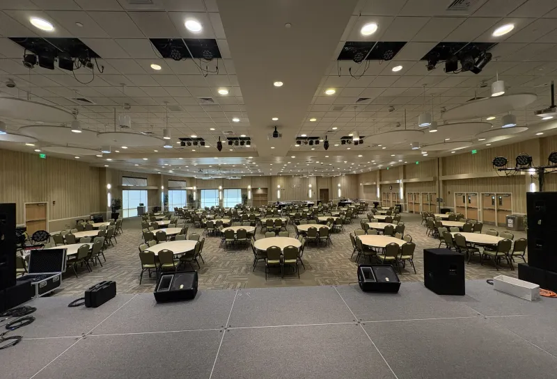 Oceti Sakowin Ballroom arranged with round tables for banquet view from stage