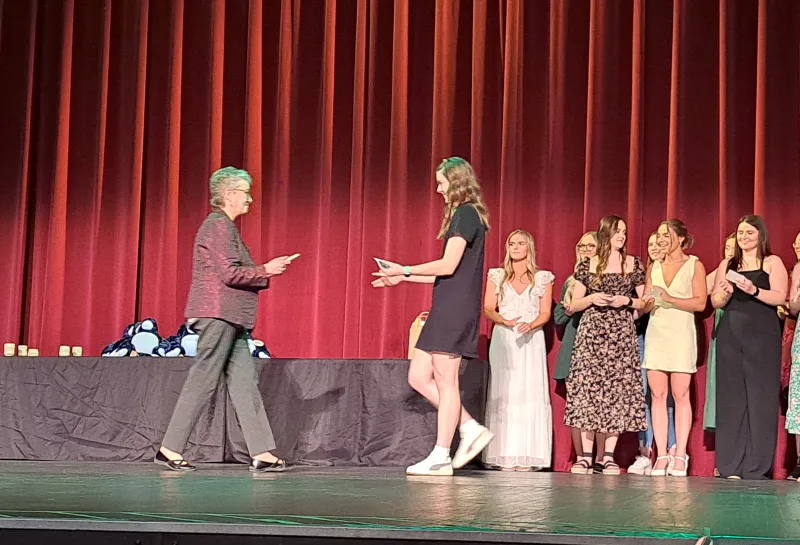 Student receiving award on stage at the Spring 2024 SoDAA Sendoff.