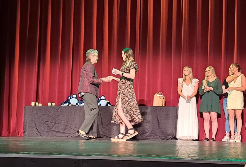 Student receiving award on stage at the Spring 2024 SoDAA Sendoff.