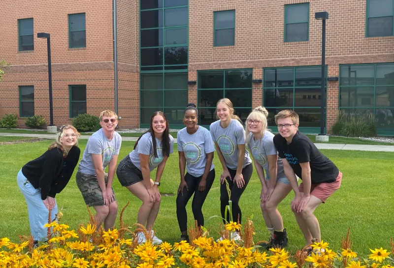 Students posing by flowers